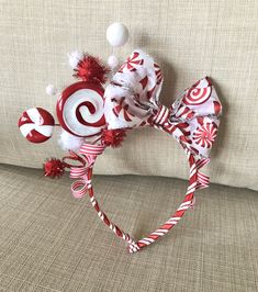 a red and white headband with candy canes on it sitting on a couch