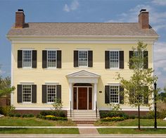 a large yellow house with black shutters