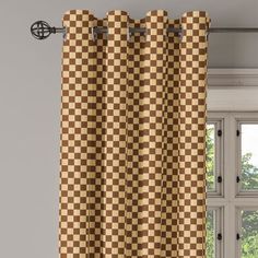 a brown and white checkered curtain hanging in front of a window