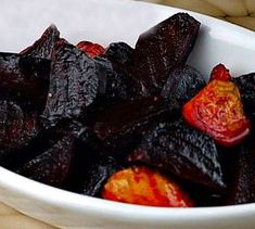 a white bowl filled with sliced up beets on top of a wooden table next to a sign that says organic & citrus dressing