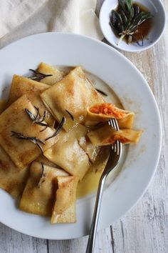 a white plate topped with dumplings and sauce