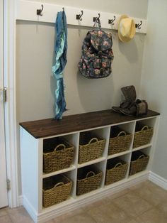 a coat rack with baskets and coats hanging on it's sides next to a door