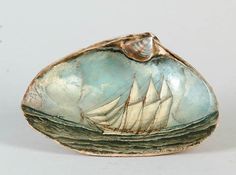 a small shell with a sailboat on it