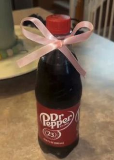 a bottle with a pink ribbon tied around it