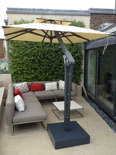 an outdoor living area with couches and umbrella