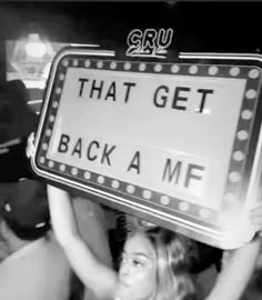 a woman holding up a sign that says, that get back a m f