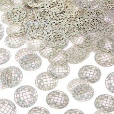 many silver circles are scattered on a white tablecloth that has been sequinized onto it