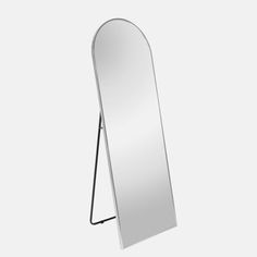 a mirror that is sitting on top of a metal stand in front of a white wall