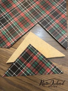 three pieces of plaid fabric laid out on top of each other, one with a piece of cardboard sticking out of it