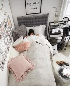 a girl is sleeping in her bed with pillows and blankets on the floor next to them