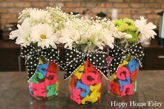 three decorated mason jars with flowers in them