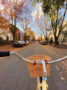 a bicycle is parked on the street in front of some houses and trees with autumn leaves