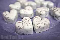 white heart shaped marshmallows on a purple surface with brown sprinkles