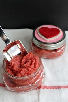 two jars filled with red sugar and a spoon