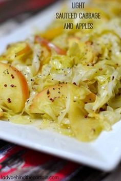 a white plate topped with cabbage and apples