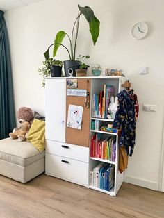 a living room with a book shelf and a stuffed animal