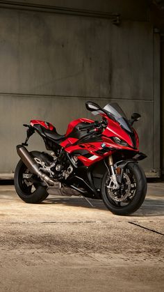 a red motorcycle parked in front of a building