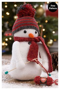 a knitted snowman with a red hat and scarf