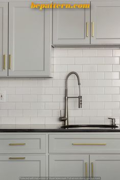 a kitchen with white cabinets and gold trimmings on the backsplashes