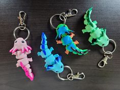 four different colored plastic key chains on a table