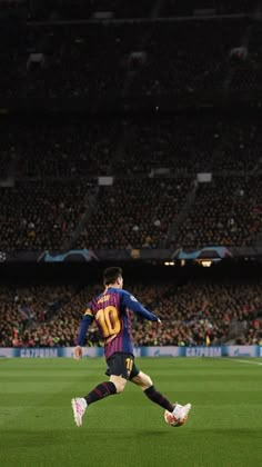 a soccer player is running on the field in front of an empty stadium full of people