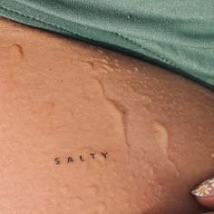 a woman's stomach with the word salty written in cursive writing on it