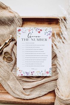 the wedding game is laid out on top of a wooden tray with flowers and feathers