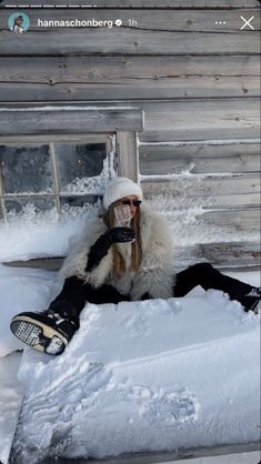 a person sitting in the snow with a snowboard on their feet and wearing a face mask