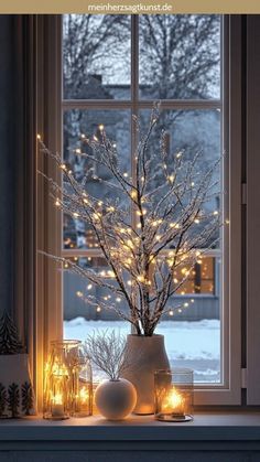 a window sill filled with candles and a vase full of branches covered in lights