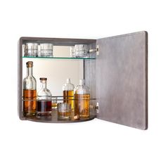 an open medicine cabinet filled with bottles and glasses