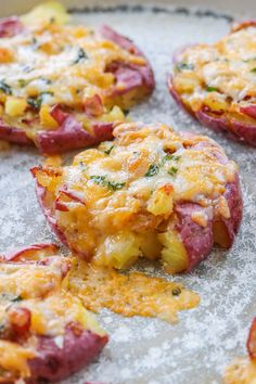 baked potatoes with cheese and vegetables on a baking sheet, ready to be cooked in the oven