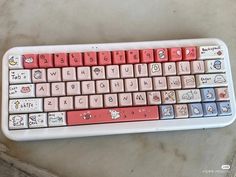 a pink and white keyboard with hello kitty stickers on it's backlit keys