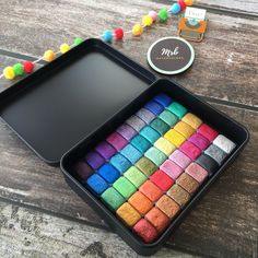 there are many different colored candies in the box on the wooden table next to it