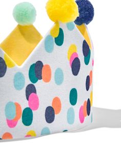 a colorful polka dot crown with pom - poms on the front and sides