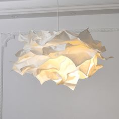 a light fixture hanging from the ceiling in a room with white walls and trimmings