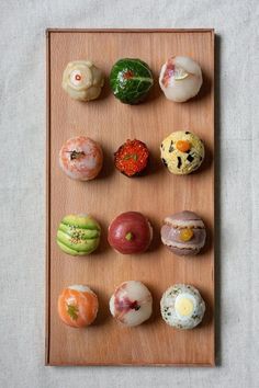 an assortment of different types of doughnuts on a wooden tray