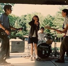 a group of young men playing guitars and singing