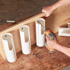 a man is using a drill to attach holes in the side of a wooden shelf