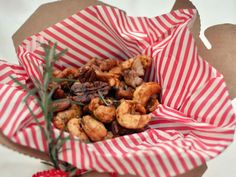 a paper bag filled with food sitting on top of a table next to a red and white striped napkin