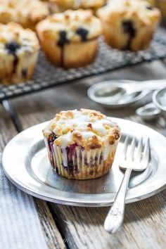 blueberry muffins on a silver plate with fork and spoon next to it