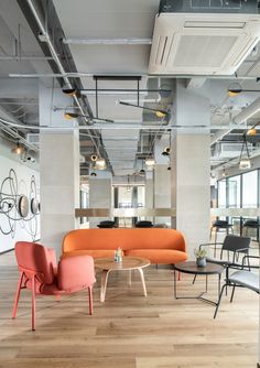 an office with chairs, tables and couches in the middle of the flooring