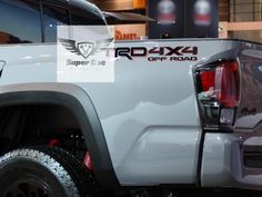 the rear end of a white truck parked in a showroom