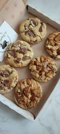 chocolate chip cookies with peanut butter and pecans are in a box on the table