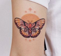 a small butterfly tattoo on the side of a woman's leg