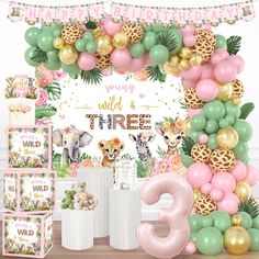 an animal themed birthday party with pink, green, and gold balloon garlands on the wall