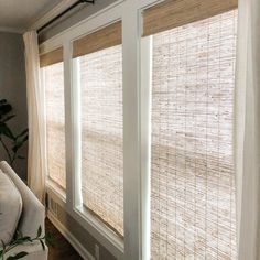 the blinds in this living room are made out of natural bamboo and have white trim