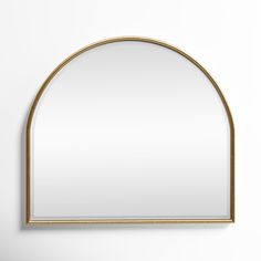 an arched mirror hanging on the wall with a gold frame and white walls behind it