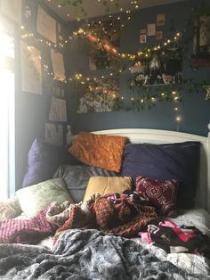 a bed with lots of pillows and blankets on it