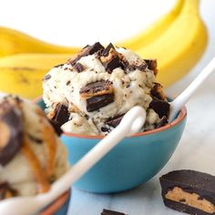 two bowls filled with ice cream and chocolate chips next to banana's on the table