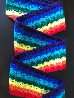 three crocheted headbands with different colors on them sitting next to each other